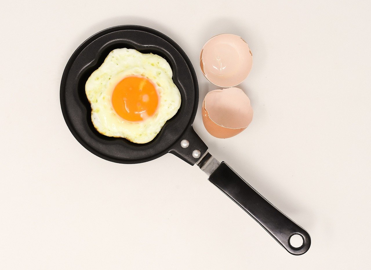A Star shape cooking pan with an egg on it, the egg's shell is around 